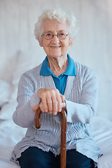 Image showing Elderly woman, sitting portrait and smile on bed with happiness, walking stick and relax in nursing home. Happy senior lady, bedroom and cane for support, healthcare and wellness in retirement house