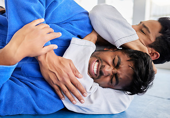 Image showing Karate, martial arts and men in choke hold on gym mat for wrestling game, match and practice. Fitness, sport and male athletes doing taekwondo for exercise, workout and training in self defense class