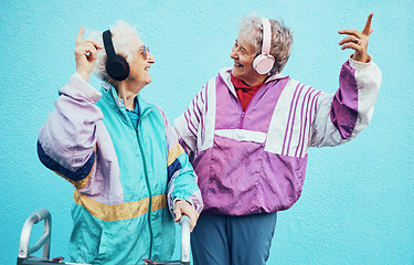 Image showing Friends, city and senior women with headphones on blue background wall listening to audio, music and radio. Fashion, style and elderly females enjoy retirement, freedom and dancing in urban town