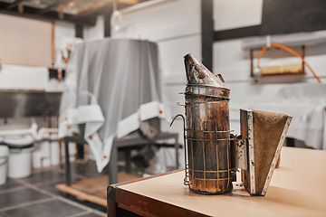 Image showing Sustainability, beekeeping and copper smoker in warehouse or factory at bee farm. Farming, bees and growth in agriculture, eco friendly honey manufacturing industry and safety in honeycomb production