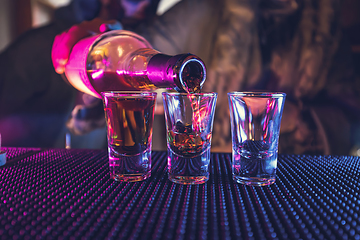 Image showing Bartender pouring and serving drinks