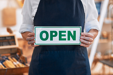 Image showing Closeup, open sign or small business woman, hands or retail store for shopping, service or product. Board, welcome and information at honey shop, organic or health food blurred background with owner