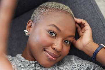 Image showing Smile, black woman on sofa and phone selfie, taking a profile picture for social media or online dating app. Relax, happy and woman laying on living room couch taking photo for self love from above.