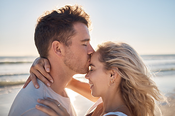 Image showing Love, dating and couple kiss at beach enjoying romantic holiday, vacation and honeymoon by ocean. Happiness, summer and young man and woman embrace, show affection and bonding together in nature