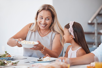 Image showing Happy, lunch and grandmother with child at the table eating a meal together with their family. Happiness, conversation and senior woman talking, eating and bonding at dinner, party or event at a home