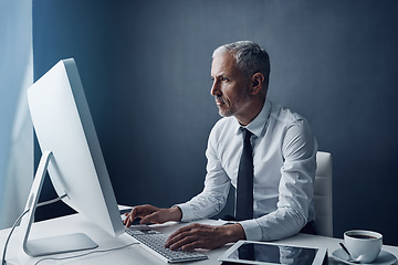 Image showing Typing accountant, computer and elderly man in studio, working and isolated on a dark background mockup. Focus, writing or serious executive at desktop for reading email, research or business auditor