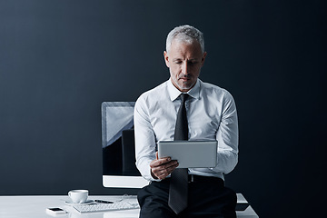 Image showing Ceo, tablet and senior man at desk in studio isolated on a dark background mockup space. Technology, reading and serious manager focus on working on project, email or online research for business app