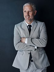 Image showing Senior businessman in suit, arms crossed and smile on dark background, happy lawyer in studio. Confidence, pride and professional career for executive ceo attorney, business owner and law firm boss.