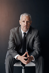 Image showing Mockup, chair and serious portrait of businessman, lawyer or attorney, confidence on dark background and studio. Boss, ceo and professional business owner, proud senior executive director at law firm