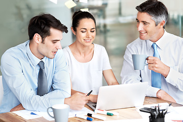 Image showing Business people, team and laptop in office for planning, collaboration and accounting discussion. Men and a woman together in at desk with tech and paperwork for tax, budget or brainstorming strategy