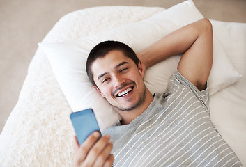 Image showing Bed, phone and a man reading a message at home with chat notification or network for communication. Young person relax with a smartphone and internet connection for chat on mobile app or social media