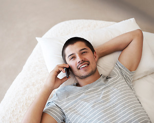 Image showing Phone call, talking and a happy man relax on a bed for a chat, conversation or communication with contact. Casual model person smile and thinking at home with smartphone network and connection