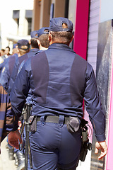 Image showing Police, group and walking in city for safety, law enforcement and urban patrol from the back. Security, team of people and public service cops with legal power, authority and crime guard in street