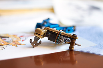 Image showing Creative, table and a tattoo gun for art, piercing or professional ink work in a studio. Creativity, tool and a machine or product for tattoos, artistic expression and needle for color on a desk