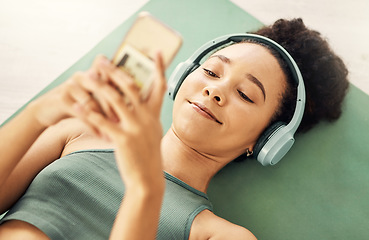 Image showing Relax, phone and yoga woman with music headphones on floor for fitness, break or texting at home from above. Workout, rest and sporty lady with smartphone and earphones for wellness, app or podcast