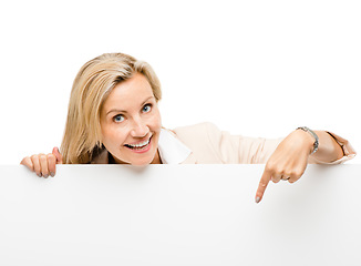 Image showing Banner, portrait and mature woman with hand pointing in studio to mockup, timeline or news on white background. Face, smile and happy lady show steps, menu or promo, announcement or coming soon deal