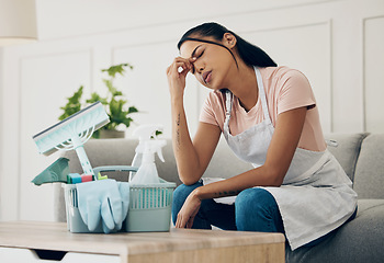 Image showing Tired, exhausted and woman cleaning a house with supplies, chemical or tools. Young female or cleaner in a clean lounge with headache or stress at an apartment or room with fatigue or problem