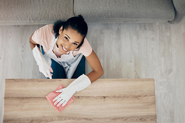 Image showing Cleaning, table and portrait of a woman in a house to clean with supplies, chemical and cloth. Above young female or cleaner in a lounge, apartment or room with a smile to polish wood or wipe dirt