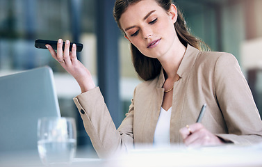 Image showing Business woman, writing and speaker phone for communication, planning or strategy at the office. Female person or employee in project management with mobile smartphone app or voice note at workplace