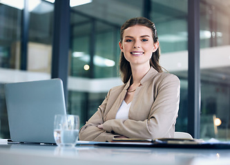 Image showing Business woman, arms crossed and working at desk with laptop, lawyer with confidence and smile in portrait. Professional mindset, female employee at law firm with mission, attorney and legal research