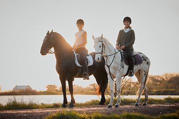 Image showing Horse riding, sunset and hobby with friends in nature on horseback by the lake during a summer morning. Countryside, equestrian and female riders outdoor together for travel, hobby or adventure