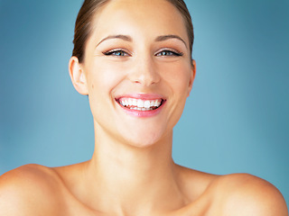 Image showing Smile, cosmetics and portrait of happy woman with dermatology, skincare and makeup on blue background. Happiness, skin care and wellness, face of model with beauty and facial glow on studio backdrop.