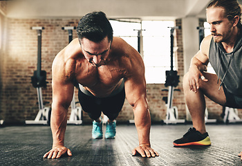 Image showing Push up, strong and man or personal trainer in gym support, motivation and helping body builder in training. Muscle, fitness and focus of people exercise or workout on floor, advice or accountability