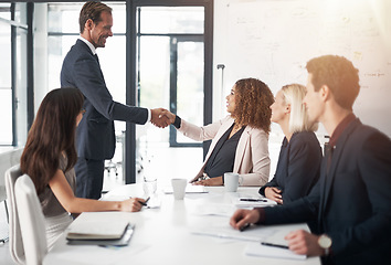 Image showing Business people, handshake and meeting for teamwork, agreement or partnership in conference at the office. Businessman shaking hands with woman for b2b, corporate growth or hiring at the workplace