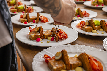 Image showing Chef in the midst of plating dishes