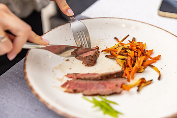 Image showing Woman eating delicious steak