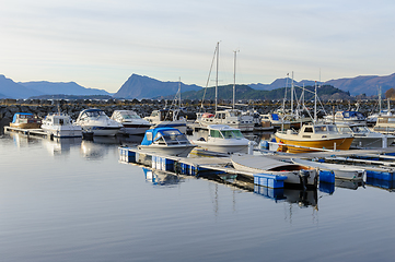 Image showing boats within breakwater reflecting in blue the sea