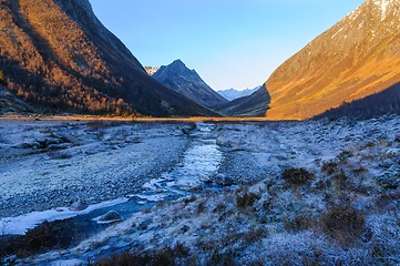 Image showing frozen landscape in the foreground with ice in a river flowing t