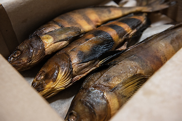 Image showing Smoked fish in craft paper box.