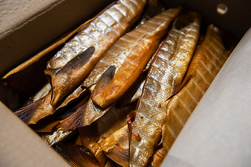 Image showing Smoked fish in craft paper box.