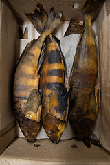 Image showing Smoked rock trout fish in craft paper box.