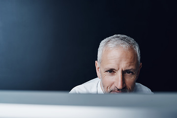 Image showing Technology, man working on his computer and against a studio background. Connectivity or social networking, research or website and mature businessman browsing internet at desktop in backdrop