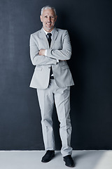 Image showing Studio portrait of mature man in suit, arms crossed and smile on dark background. Confidence, pride and professional career for happy executive businessman or senior business owner or successful ceo.