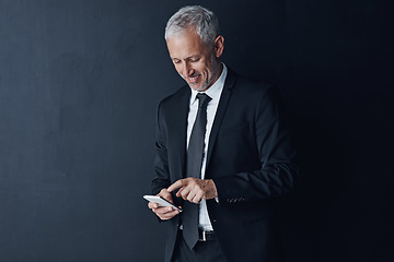 Image showing Business, ceo and mature man with a smartphone, connection and contact on a dark studio background. Male person, employee and consultant with a cellphone, mobile app and network with online reading