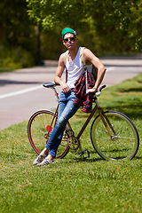 Image showing Student man, fashion and bicycle at campus with sunglasses, confident and sustainable travel in summer. Young male person, gen z guy and retro bike in sunshine for eco friendly transport at college