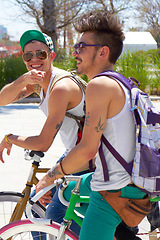 Image showing Men, students and friends with back, bicycle and sustainable transportation on road in summer sunshine. Young gen z people, retro bike and outdoor together in street with travel on university campus