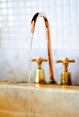 Image showing Faucet, copper and tap with water running for cleaning, washing and hygiene in kitchen or bathroom. Plumbing, home decoration and closeup of stream of liquid, aqua and drops in basin for cleansing