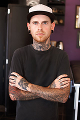 Image showing Punk, tattoos and portrait of a male artist standing with crossed arms for confidence in his studio. Serious, cool and face of grunge man with edgy, funky and body art or ink creative business store.