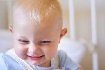 Image showing Funny, children and baby in the crib of a nursery in his home for growth, child development or curiosity. Kids, laughing and toddler with a male or boy child standing in his cot looking adorable