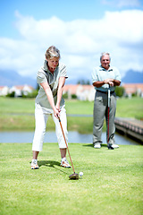 Image showing Mature, woman or golfer playing golf for fitness, workout or stroke exercise on a course in retirement. Senior couple, golfing or serious lady training in sports game to swing with her club or driver