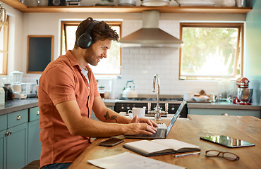 Image showing Headphones, home kitchen and man on laptop streaming music, online social media or reading web info, news or blog. Smile, typing and person listening to audio podcast while working remote on project