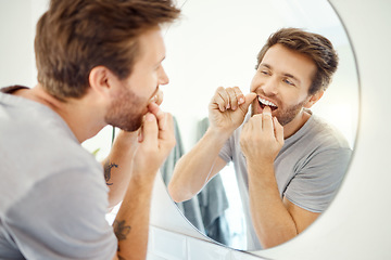 Image showing Dental floss, morning and mirror with man in bathroom for self care, oral hygiene and teeth. Cleaning, smile and health with face of male person at home for beauty, wellness and reflection