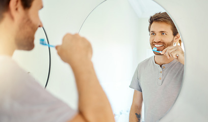 Image showing Brushing teeth, dental and mirror with man in bathroom for self care, oral hygiene and morning routine. Cleaning, smile and health with face of male person at home for beauty, wellness and toothbrush