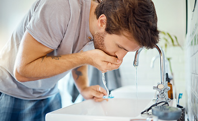 Image showing Man in bathroom, brushing teeth and rinse with water, morning cleaning routine for health and wellness in home. Dental care, mouthwash and toothbrush, male grooming for fresh breath and oral hygiene.