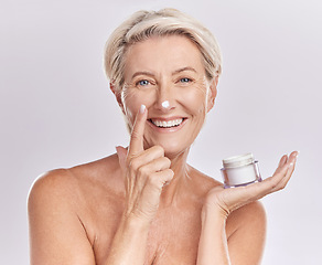 Image showing Beauty, cream and senior woman with skincare, dermatology and happy in portrait on white background. Sunscreen, moisturizer and face care, female model apply lotion with glass container and antiaging