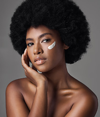 Image showing Black woman in portrait, cream and beauty with skincare and cosmetics product on studio background. Natural, afro hairstyle and African female model, dermatology with lotion and facial moisturizer